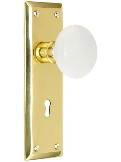 New York Style Door Set with White Porcelain Door Knobs with Keyhole in Unlacquered Brass.